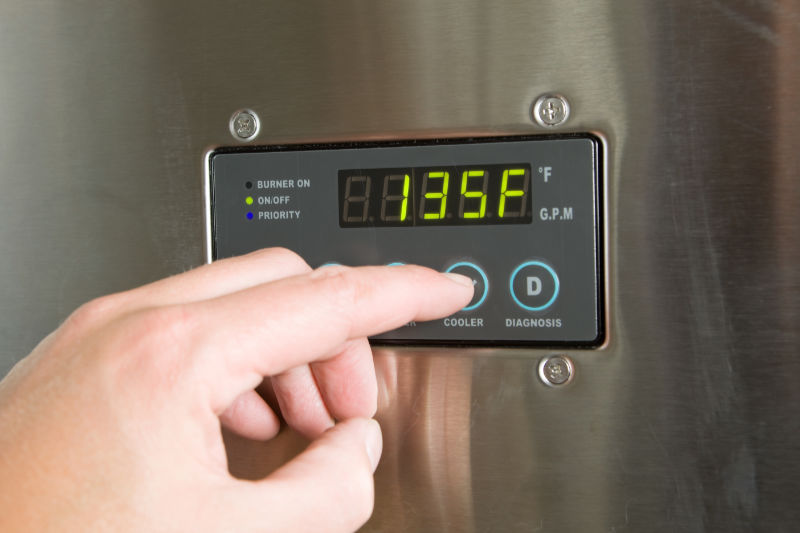 Should I Buy a Tankless Water Heater Instead? Hand setting the temperature on a water heater.