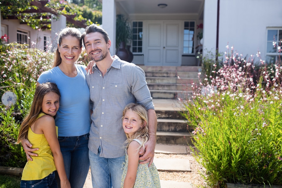 Plumbing Tips for Your Summer Rental. Portrait of family standing together on garden path.